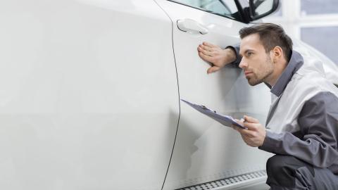 Technician examining wax treated paintwork